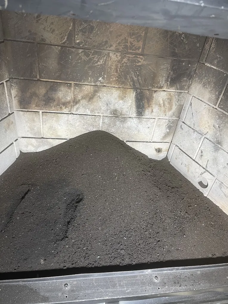 Close-up of heavy creosote buildup inside a fireplace before cleaning by Davinci Home Improvements